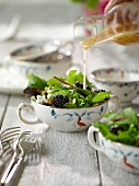 Minz-Brombeer-Salat mit Dressing begiessen