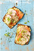 Wholemeal bread with avocado and cream cheese spread, smoked salmon and sprouts