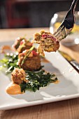 Crawfish corn fritters on a fork and plate