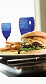 Steak House Burger with Lettuce and a Pickle with French Fries; On a Table with a Glass of Wine