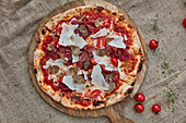 A pizza with tomato sauce, mozzarella, bresaola, truffles and Parmesan cheese
