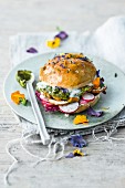 A seitan and millet burger with radishes, mojo verde, and edible flowers