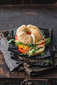A sesame bagel with salmon, arugula, and cress