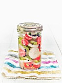 Lacto fermented daikon, radishes, onions, and cucumbers in a mason jar