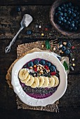 Berry smoothie bowl with bananas, chia, pumpkin seeds and oat flakes