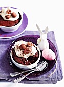 Schokoladen-Karamell-Pudding mit flüssigem Kern, mit Sahne und kleinen Schokoeiern dekoriert