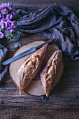 Sourdough baguette sliced in half on a rustic wooden table