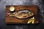 Baked carp with lemon and sauce on cutting board