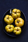 Several quinces in a black bowl