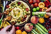 Vorspeisenplatte mit Hummus-Dip, Hühnerflügeln, Kirschen, Kichererbsen und Oliven