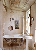 Free-standing bathtub in small bathroom with melancholy charm