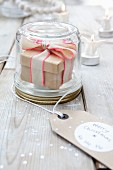 Gift box with ribbon in screw-top jar with 'Merry Christmas' tag