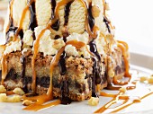 A piece of cake with ice cream, caramel, and chocolate sauce