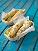 Grilled corncobs with cheese and lime
