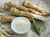 Horseradish roots and peel with grated horseradish and horseradish leaves