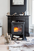 Cast iron log burner in black fire surround against black chimney breast