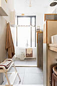 Small compartmentalised bathroom in natural shades with large window