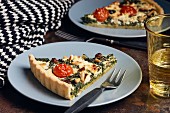 Spinach quiche with cherry tomatoes, raisins and pine nuts