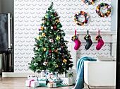Bunt geschmückter Weihnachtsbaum mit Pompoms und Geschenken