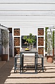 Wooden table, bar stools, barbecue and pergola on terrace