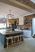 Island counter and brick wall in contemporary country-house kitchen