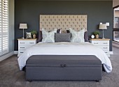 White bedside cabinets and button-tufted headboard in bedroom