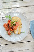 A fried redfish fillet with tomato salad