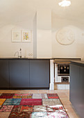 Minimalistische Küche mit grauen Fronten unter der Gewölbedecke