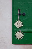 Two straw stars hung on green shutter