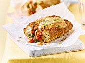 A baguette with beans, tomatoes and cheese