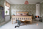 Swedish tiled stove in romantic bedroom with floral wallpaper