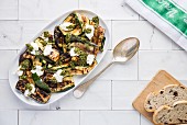 A plate of grilled courgette slices topped with a mint dressing and scattered with smoked labneh