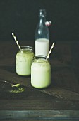 Cold refreshing iced coconut matcha latte drink in glass jars