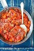 Pork chops with sage, wrapped in prosciutto, in tomato sauce