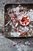 Half a pomegranate in a tray of ice cubes