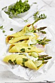 Pancake rolls with green sauce, asparagus, cucumber, and radishes