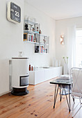 Small cylindrical stove and designer shelves in white living room