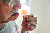 Elderly man taking a pill