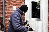 Burglar using a crowbar on a door