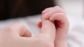 Baby grasping parent's finger