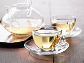 Grüner Tee in Glastasse und Glaskanne