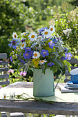 Early summer flowering perennials bouquet in a green pot