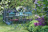 Kleine Sitzgruppe am Beet mit Alchemilla ( Frauenmantel ), Rhododendron