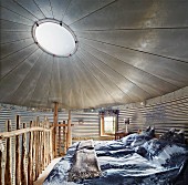 Schlafzimmer in umgebautem Getreidesilo mit Oberlicht und rustikalem Holzgeländer