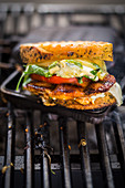 A grilled chicken, tomato, rocket and cheese sandwich