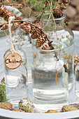 Glass jars decorated for Christmas (larch sprigs with cones, wooden decoration)