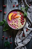 A raspberry and peach smoothie bowl with oat and amaranth pops (vegan)