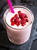 Roter veganer Smoothie mit Himbeeren im Glas