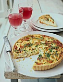 Quiche topped with herbs, sliced