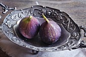 Two fresh figs in a metal bowl